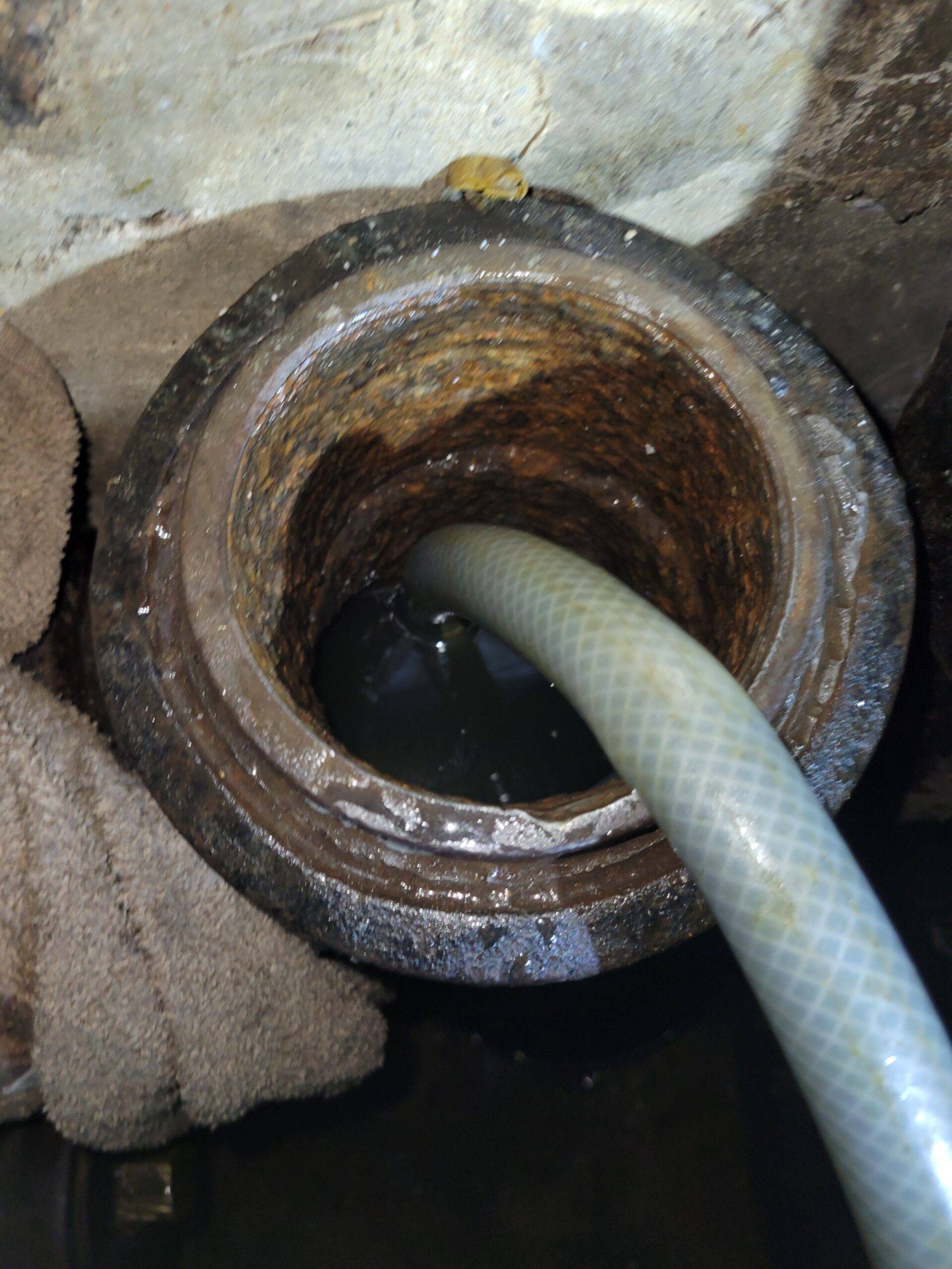 Hose connected to blow bag inside main sewer cleanout. Blow bag inserted into sewer cleanout to clear a main sewer line backup